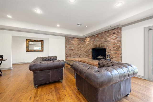 living room featuring baseboards, visible vents, recessed lighting, light wood-style floors, and a fireplace