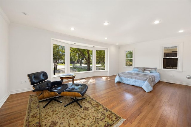 bedroom featuring visible vents, baseboards, recessed lighting, wood finished floors, and ornamental molding