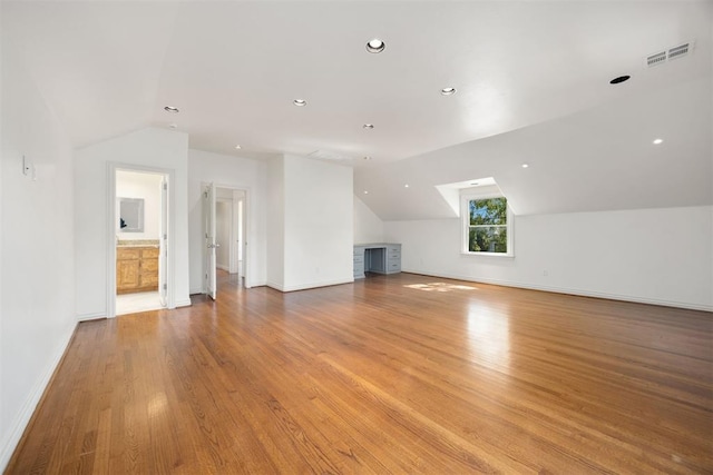 bonus room featuring lofted ceiling, baseboards, visible vents, and light wood-style floors