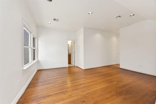 spare room with light wood-type flooring, baseboards, visible vents, and recessed lighting