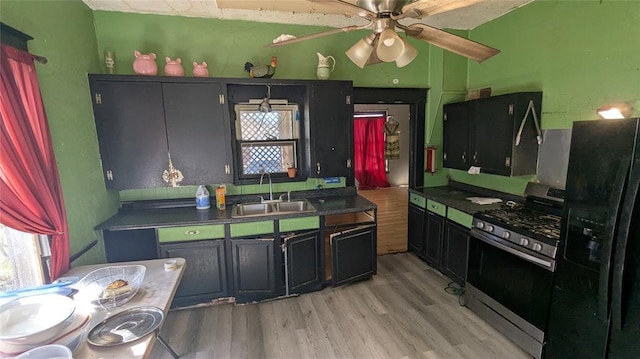 121 N High Ave, Shawnee, OK 74801 - kitchen with a ceiling fan, light wood-style floors, stainless steel range with gas stovetop, a sink, and black fridge