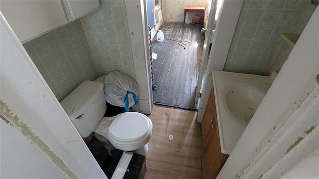 121 N High Ave, Shawnee, OK 74801 - bathroom with toilet, tile walls, and wood finished floors