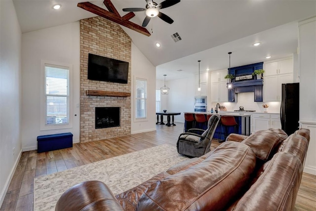 13513 NW 1st St, Yukon, OK 73099 - living room featuring plenty of natural light, a fireplace, a ceiling fan, and visible vents