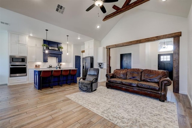 13513 NW 1st St, Yukon, OK 73099 - living room featuring visible vents, a ceiling fan, light wood finished floors, and high vaulted ceiling