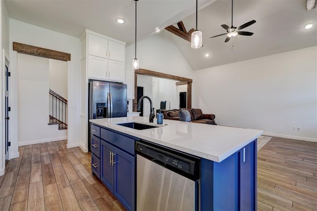 13513 NW 1st St, Yukon, OK 73099 - kitchen with blue cabinets, stainless steel dishwasher, a sink, white cabinets, and open floor plan