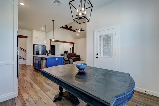 13513 NW 1st St, Yukon, OK 73099 - dining area featuring baseboards, wood finished floors, vaulted ceiling, visible vents, and stairway