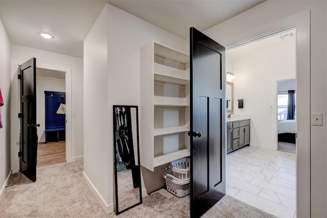 13513 NW 1st St, Yukon, OK 73099 - corridor with baseboards, visible vents, light carpet, and a sink