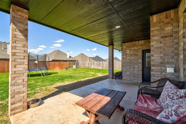 13513 NW 1st St, Yukon, OK 73099 - view of patio / terrace with a fenced backyard, a trampoline, and a residential view