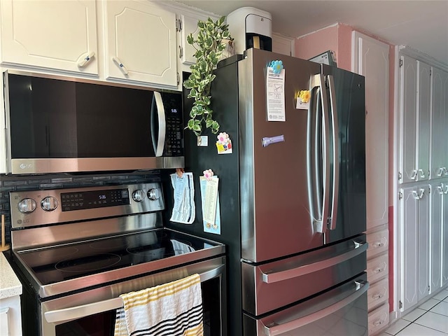 215 Justin Dr, Norman, OK 73071 - kitchen featuring appliances with stainless steel finishes, white cabinetry, light countertops, and light tile patterned floors