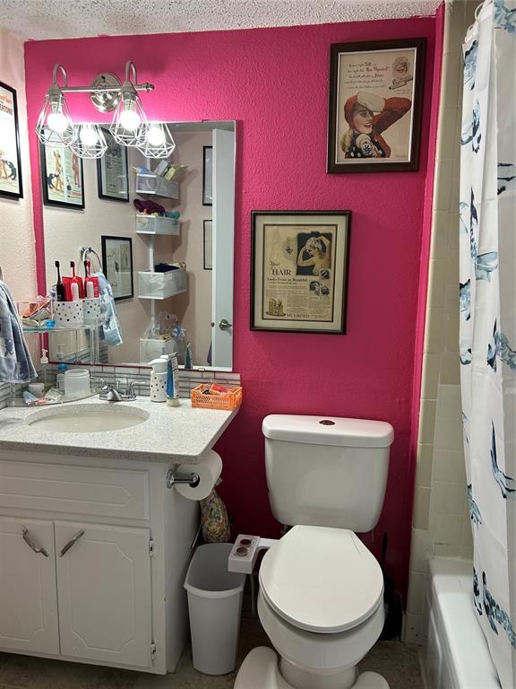 215 Justin Dr, Norman, OK 73071 - bathroom featuring toilet, a textured wall, and vanity