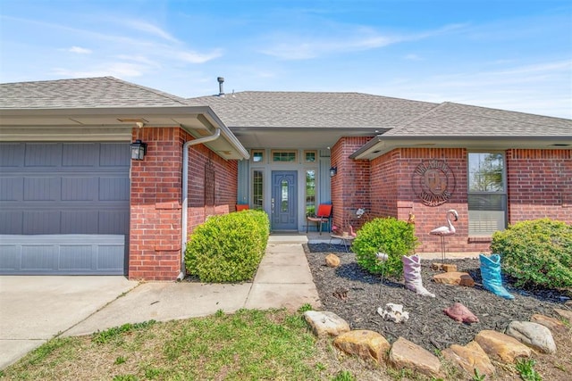 property entrance with brick siding, roof with shingles, and a garage
