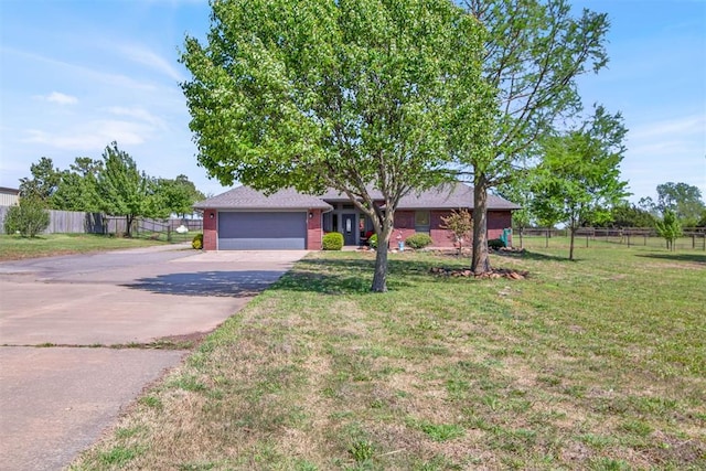ranch-style house with fence, an attached garage, a front lawn, and driveway