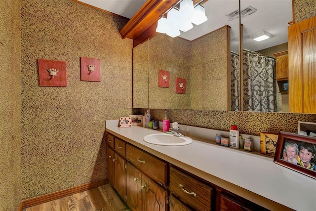 full bath featuring baseboards, vanity, wood finished floors, and visible vents