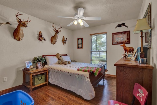 bedroom with a ceiling fan, baseboards, a textured ceiling, and dark wood finished floors