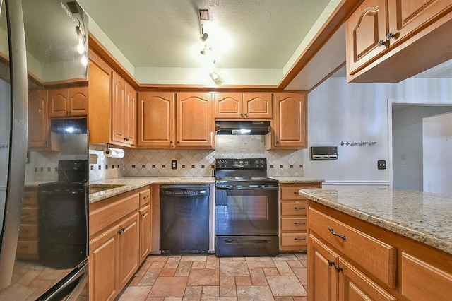 1637 NE 9th St, Moore, OK 73160 - kitchen with backsplash, stone finish floor, light stone countertops, under cabinet range hood, and black appliances