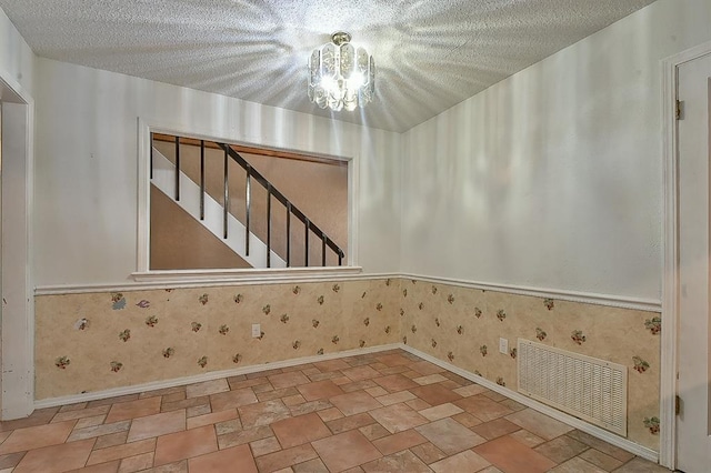 1637 NE 9th St, Moore, OK 73160 - interior space featuring baseboards, visible vents, a textured ceiling, and a notable chandelier
