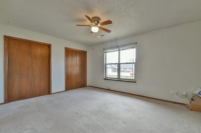 1637 NE 9th St, Moore, OK 73160 - unfurnished bedroom featuring light carpet, multiple closets, a textured ceiling, and baseboards