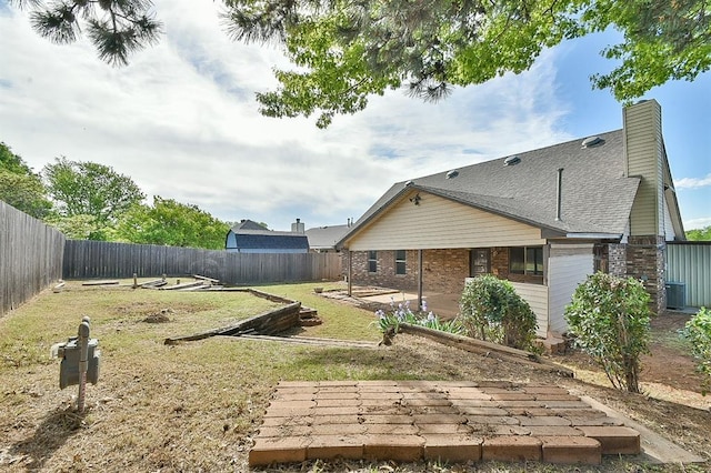 1637 NE 9th St, Moore, OK 73160 - back of house with a fenced backyard, brick siding, a patio area, and a lawn