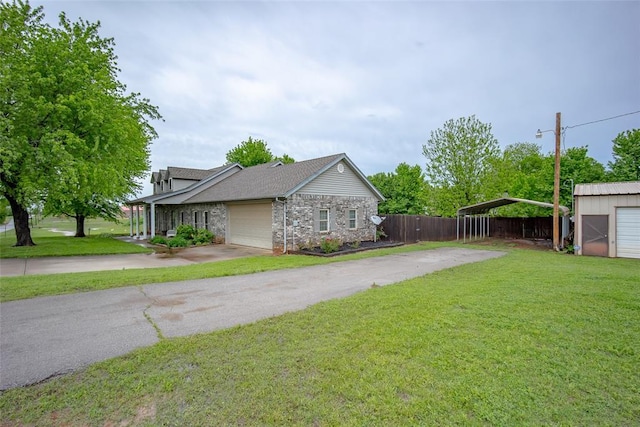view of side of property with a lawn, fence, driveway, and a carport