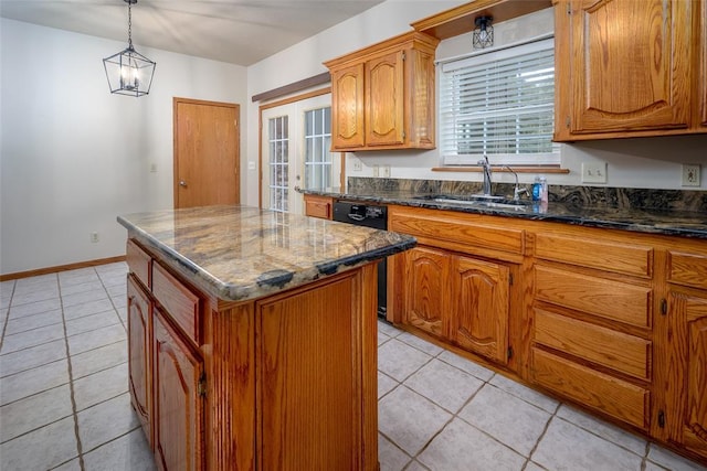 kitchen featuring brown cabinetry, a kitchen island, light tile patterned flooring, a sink, and dishwasher