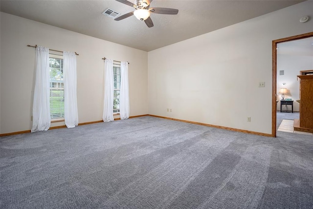 empty room with visible vents, baseboards, and ceiling fan