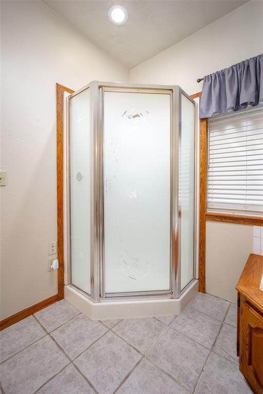 full bath featuring baseboards, tile patterned flooring, and a shower stall