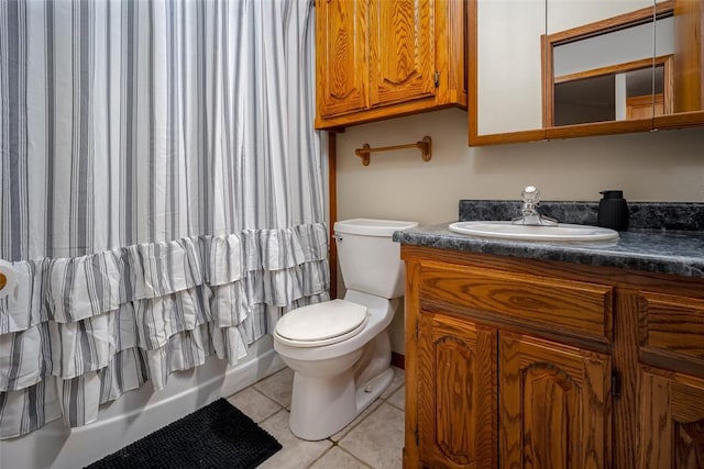 bathroom featuring tile patterned floors, shower / bath combo with shower curtain, vanity, and toilet