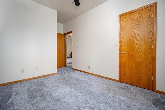 unfurnished bedroom featuring carpet flooring, a ceiling fan, and baseboards