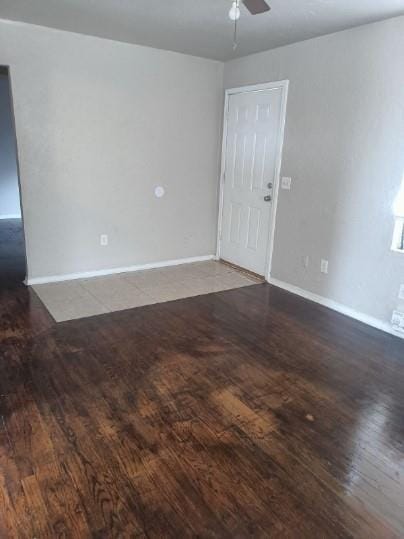 spare room with baseboards, a ceiling fan, and wood finished floors