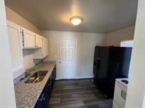 kitchen with a sink, light countertops, white cabinetry, and dark wood-type flooring
