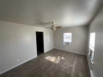 spare room featuring baseboards, ceiling fan, and dark carpet