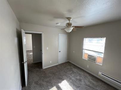 unfurnished bedroom with ceiling fan, carpet floors, baseboards, cooling unit, and a baseboard heating unit