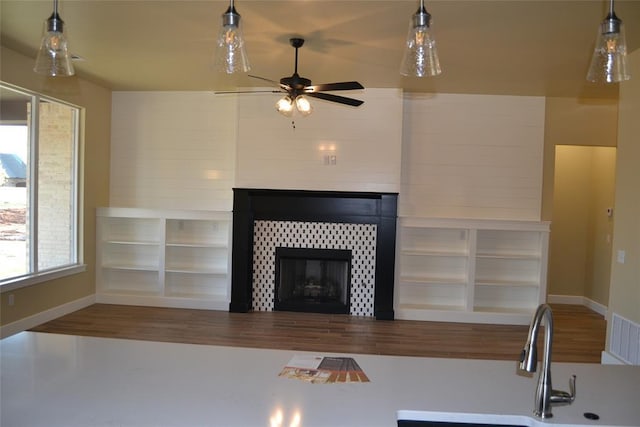 1124 NW 17 Th Pl, Newcastle, OK 73065 - unfurnished living room featuring visible vents, wood finished floors, a fireplace, ceiling fan, and a sink