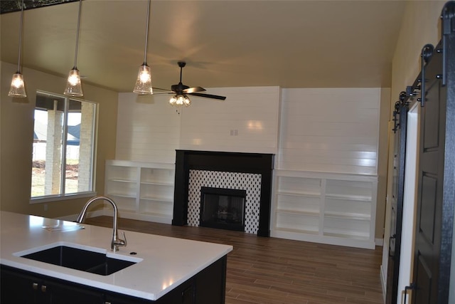 1124 NW 17 Th Pl, Newcastle, OK 73065 - kitchen with dark wood-style flooring, ceiling fan, light countertops, a tile fireplace, and a sink