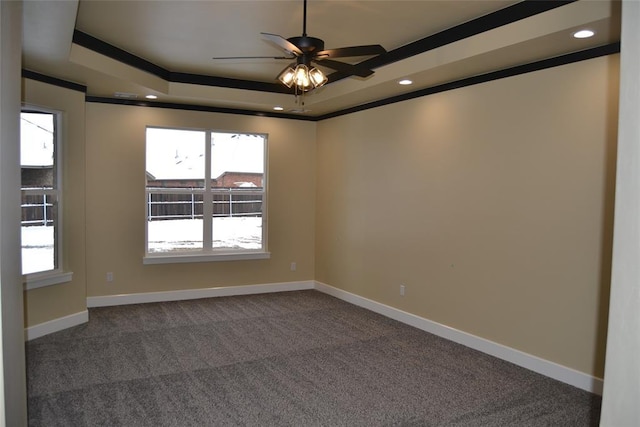 1124 NW 17 Th Pl, Newcastle, OK 73065 - empty room featuring a healthy amount of sunlight, a raised ceiling, ceiling fan, and dark colored carpet