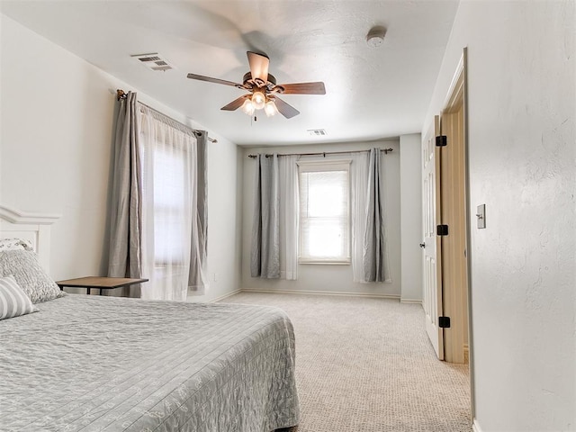 bedroom featuring a ceiling fan, visible vents, light carpet, and baseboards