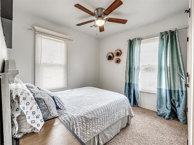bedroom with ceiling fan and multiple windows