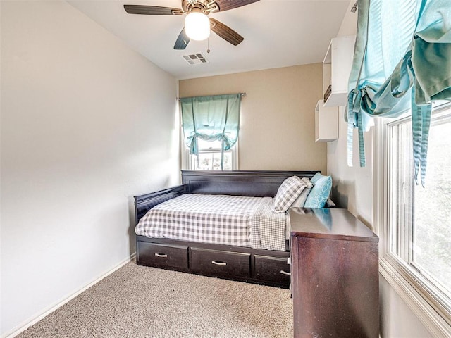 carpeted bedroom featuring baseboards, visible vents, a ceiling fan, and multiple windows