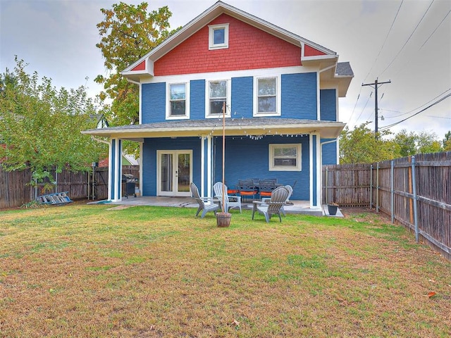 back of property with french doors, a fenced backyard, a patio area, and a lawn