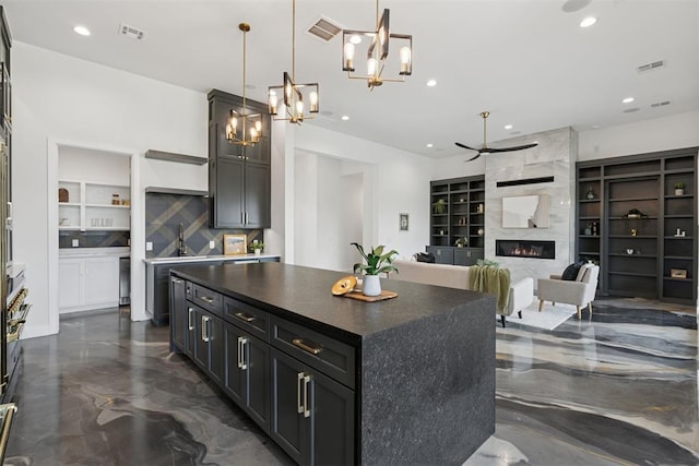 1233 Collis Ct, Newcastle, OK 73065 - kitchen featuring built in shelves, a premium fireplace, a chandelier, recessed lighting, and ceiling fan