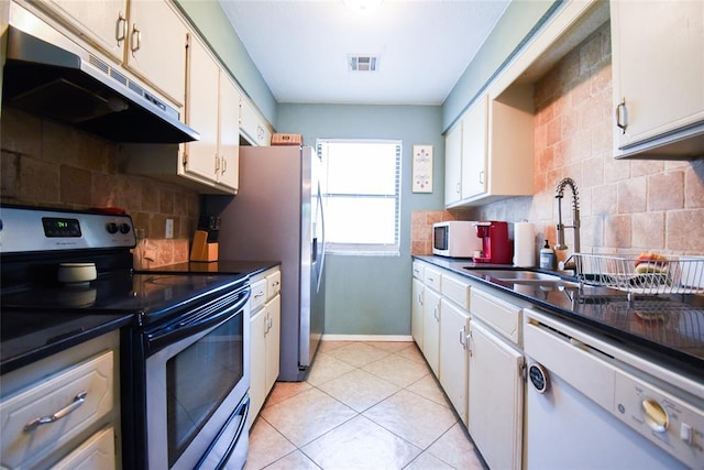 kitchen featuring a sink, visible vents, stainless steel appliances, under cabinet range hood, and backsplash