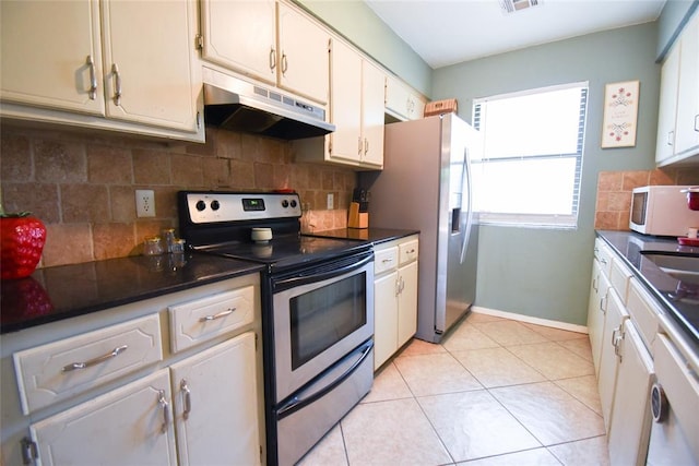 kitchen with stainless steel appliances, under cabinet range hood, backsplash, dark countertops, and visible vents