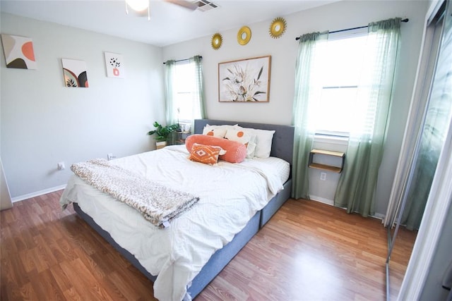 bedroom featuring visible vents, ceiling fan, wood finished floors, and baseboards