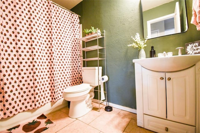 bathroom featuring toilet, vanity, a textured wall, and tile patterned floors
