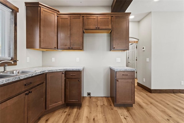 kitchen featuring recessed lighting, a sink, light countertops, and light wood-style flooring
