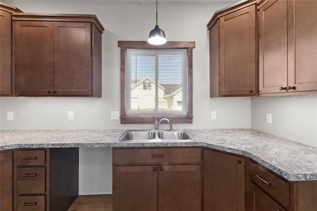 kitchen featuring light countertops, pendant lighting, and a sink