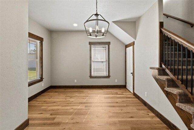 unfurnished dining area with recessed lighting, light wood finished floors, baseboards, a chandelier, and stairs