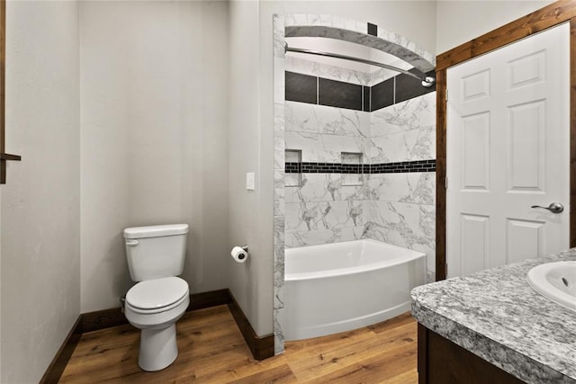 full bathroom featuring wood finished floors, vanity, tub / shower combination, baseboards, and toilet