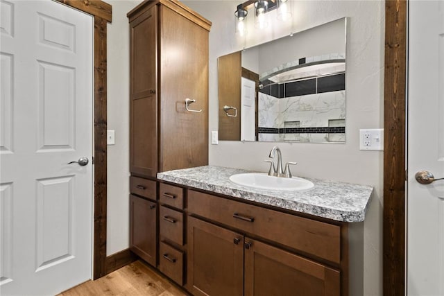 full bath featuring walk in shower, wood finished floors, and vanity