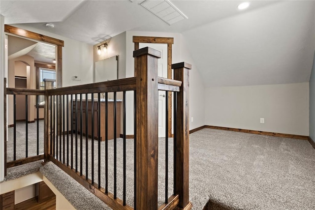 additional living space with baseboards, vaulted ceiling, visible vents, and carpet flooring
